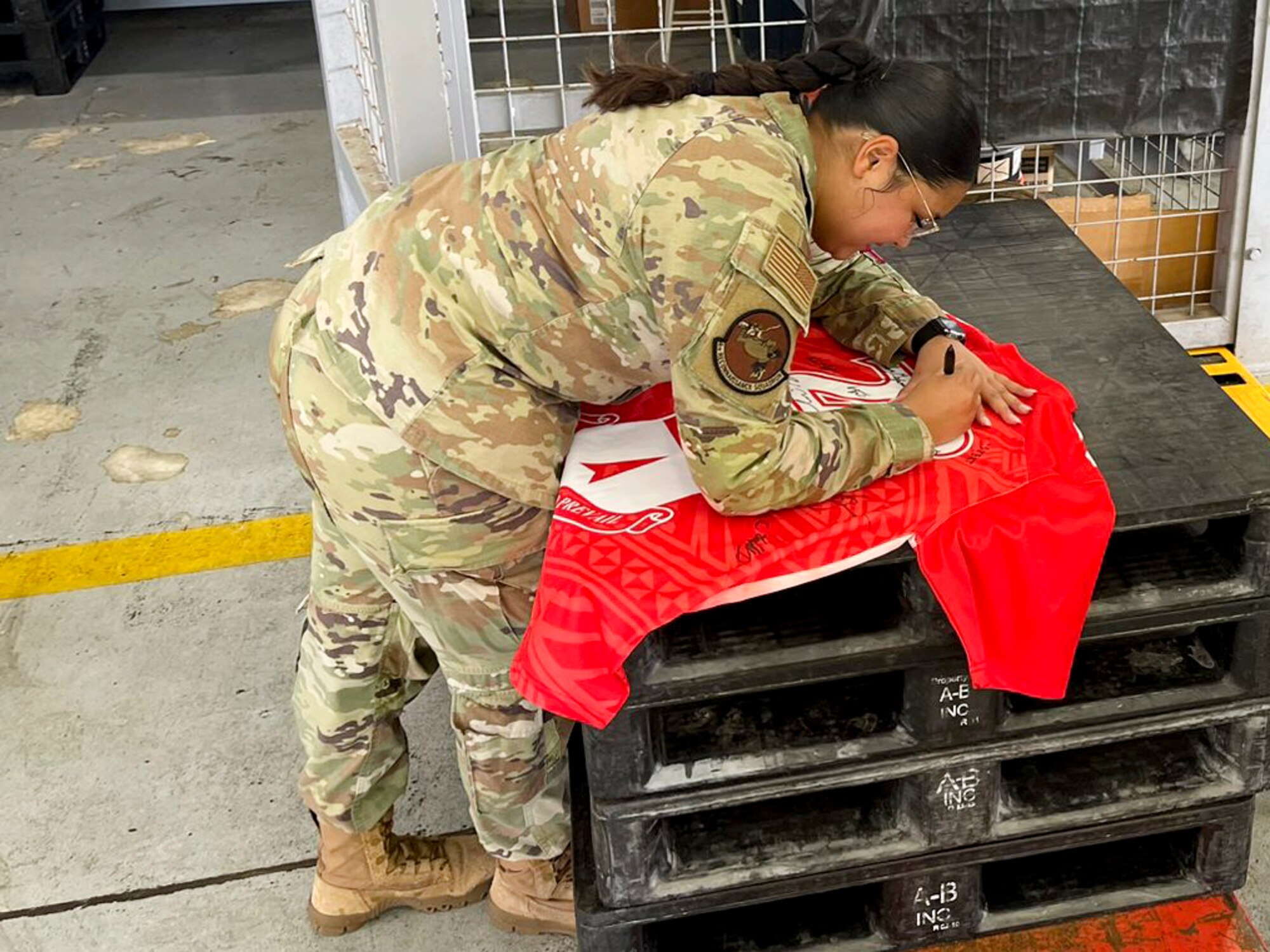 U.S. Air Force Senior Airman Gabriella Balines, a decentralized material support specialist assigned to the 4th Reconnaissance Squadron, signs the Linebacker of the Week jersey at Andersen Air Force Base, Guam, May 3, 2023. The Team Andersen Linebacker of the Week recognizes outstanding enlisted, officer, civilian and total force personnel who have had an impact on achieving Team Andersen’s mission, vision and priorities. (Courtesy photo)