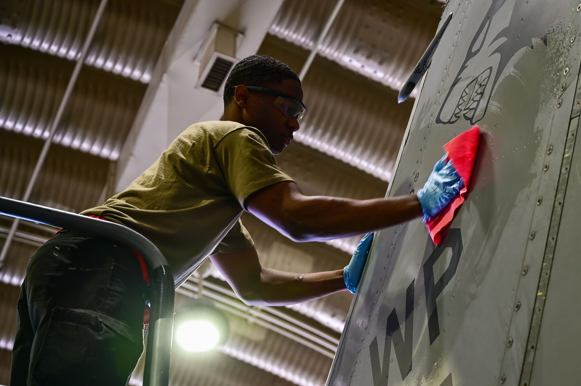 Senior Airman Connor Young, 8th Maintenance Squadron aircraft structural maintenance journeyman, washes the tail of an F-16 Fighting Falcon assigned to the 80th Fighter Squadron prior to the application of a 70th anniversary heritage decal at Osan Air Base, Republic of Korea, May 1, 2023. Before the application, the aircraft's surface must be thoroughly cleaned to assist the adhesion process. (U.S. Air Force photo by Tech. Sgt. Timothy Dischinat)