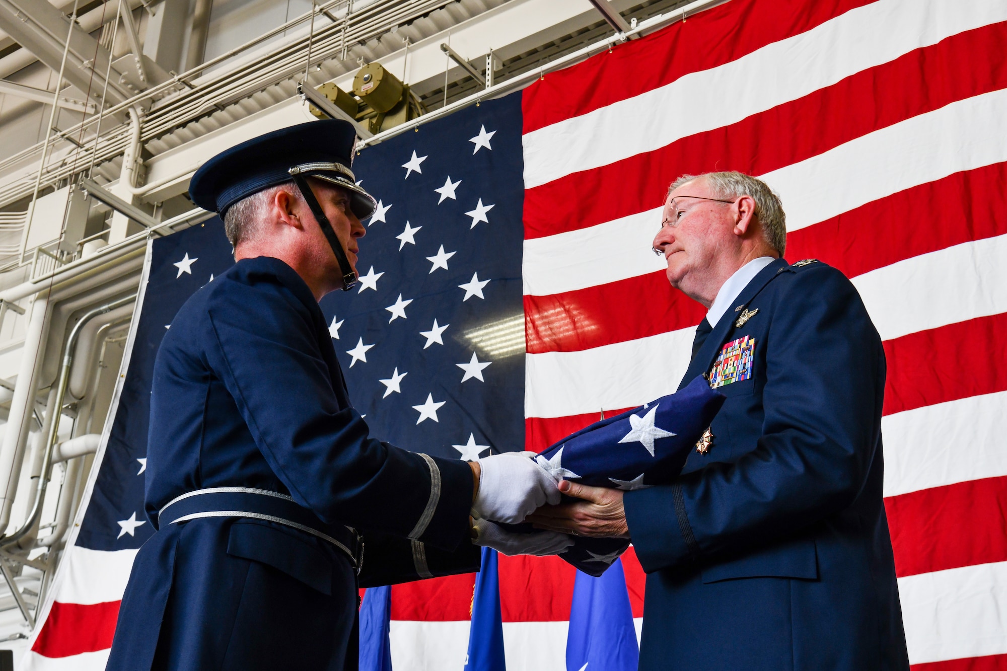 Lt. Col. Scott Allen, an honor guardsman assigned to the 910th Airlift Wing, presents a flag to Col. Jeff Van Dootingh, the commander of the 910th AW, May 6, 2023, at Youngstown Air Reserve Station, Ohio.