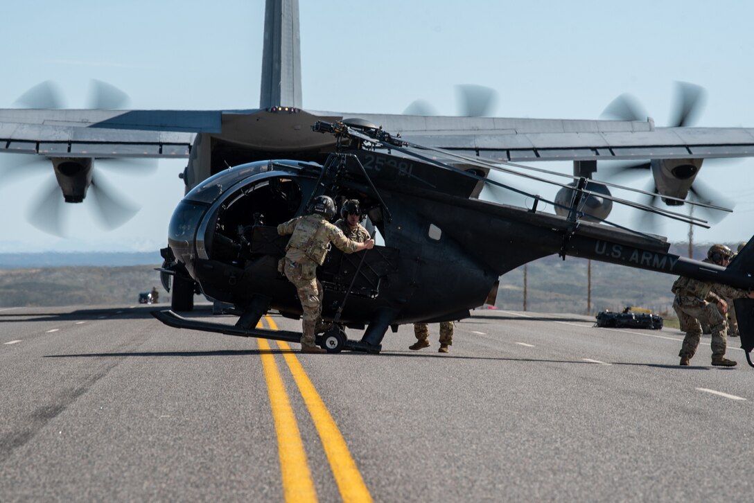 Members of the 160th Special Operations Aviation Regiment offload an MH-6M Little Bird from an MC-130J Commando II on Highway 789 during Exercise Agile Chariot near Riverton, Wyoming, May 2, 2023. Agile Chariot tested Agile Combat Employment capabilities, including using smaller, more dispersed locations and teams to rapidly move and support aircraft, pilots and other personnel wherever they’re needed. (U.S. Air National Guard photo by Master Sgt. Phil Speck)