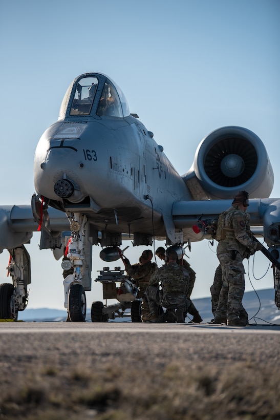 Airmen with the 127th Fighter Wing conduct an Integrated Combat Turn weapons reload on one of their A-10 Thunderbolt IIs on Highway 287 in Wyoming during Exercise Agile Chariot, April 30, 2023, honing capabilities linked to Agile Combat Employment. Instead of relying on large, fixed bases and infrastructure, ACE employs smaller, more dispersed locations and teams to rapidly move aircraft, pilots and other personnel as needed. Under ACE, millions of miles of public roads can serve as functional runways with Forward Arming and Refueling Points when necessary. (U.S. Air National Guard photo by Master Sgt. Phil Speck)