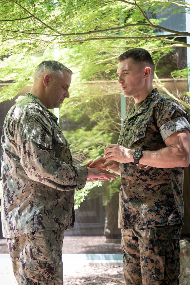 Navy Chaplain Lieutenant Kyle Lambertson, right, anoints the hands of Senior Chief Petty Officer Michael Corapi, left, the Senior Enlisted Advisor of Naval Health Clinic Cherry Point during a Blessing of the Hands ceremony held Tuesday, May 9 aboard Naval Health Clinic Cherry Point.  The ceremony, held as part of National Nurses Week, honored Sailors and civilians involved in patient care and administration aboard the facility.