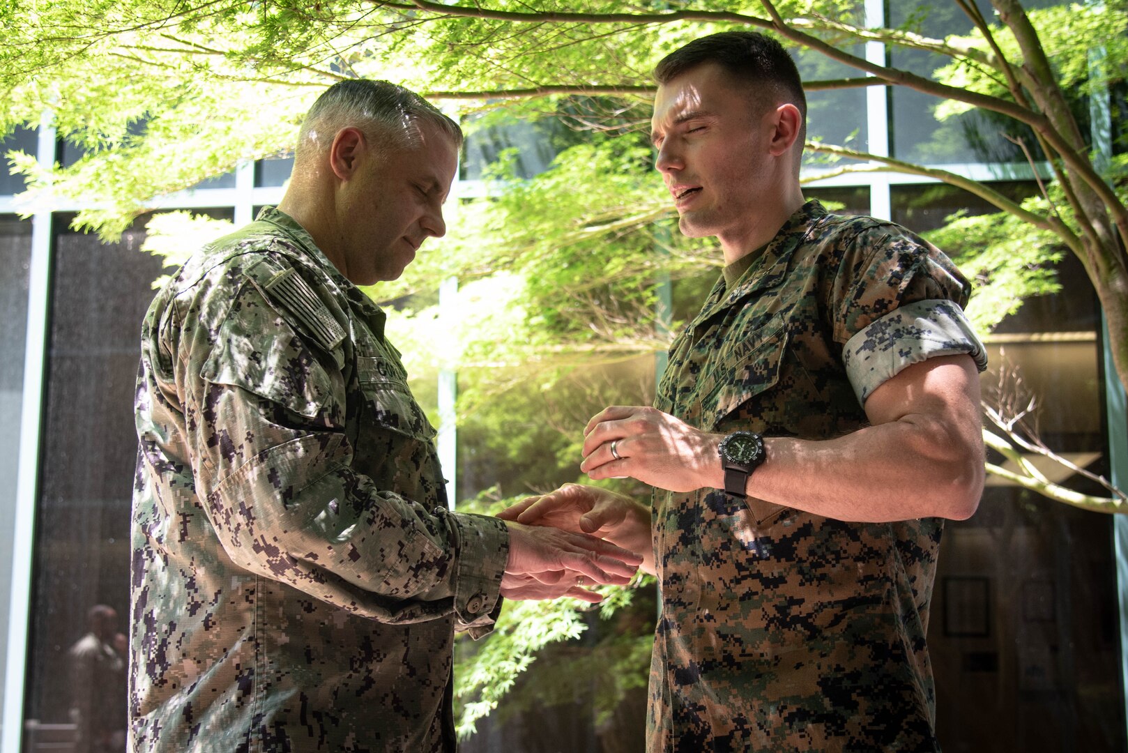 Navy Chaplain Lieutenant Kyle Lambertson, right, anoints the hands of Senior Chief Petty Officer Michael Corapi, left, the Senior Enlisted Advisor of Naval Health Clinic Cherry Point during a Blessing of the Hands ceremony held Tuesday, May 9 aboard Naval Health Clinic Cherry Point.  The ceremony, held as part of National Nurses Week, honored Sailors and civilians involved in patient care and administration aboard the facility.