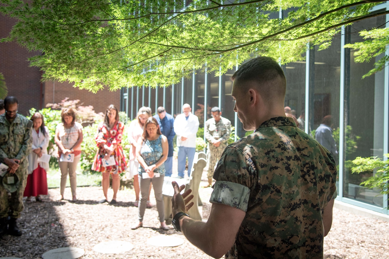 Navy Chaplain Lieutenant Kyle Lambertson, right, prays during a Blessing of the Hands ceremony conducted Tuesday, May 9 aboard Naval Health Clinic Cherry Point.  The ceremony, held as part of National Nurses Week, honored Sailors and civilians involved in patient care and administration aboard the facility.