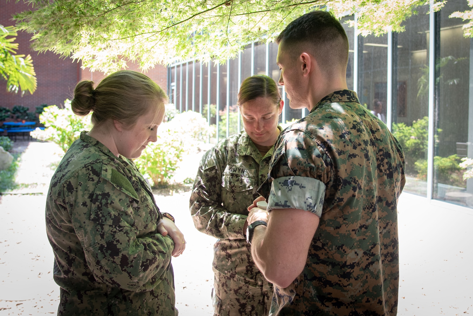 Navy Chaplain Lieutenant Kyle Lambertson, right, prays with Navy Lieutenants Sara Cruz, left, and Amanda Gwyn, center, during a Blessing of the Hands ceremony conducted Tuesday, May 9 aboard Naval Health Clinic Cherry Point.  

The ceremony, held as part of National Nurses Week, honored Sailors and civilians involved in patient care and administration aboard the facility.