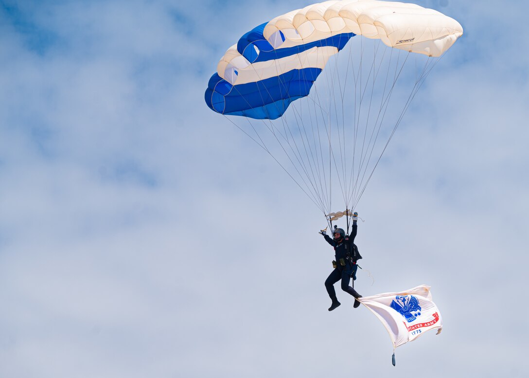 A parachute performer glides to the ground.