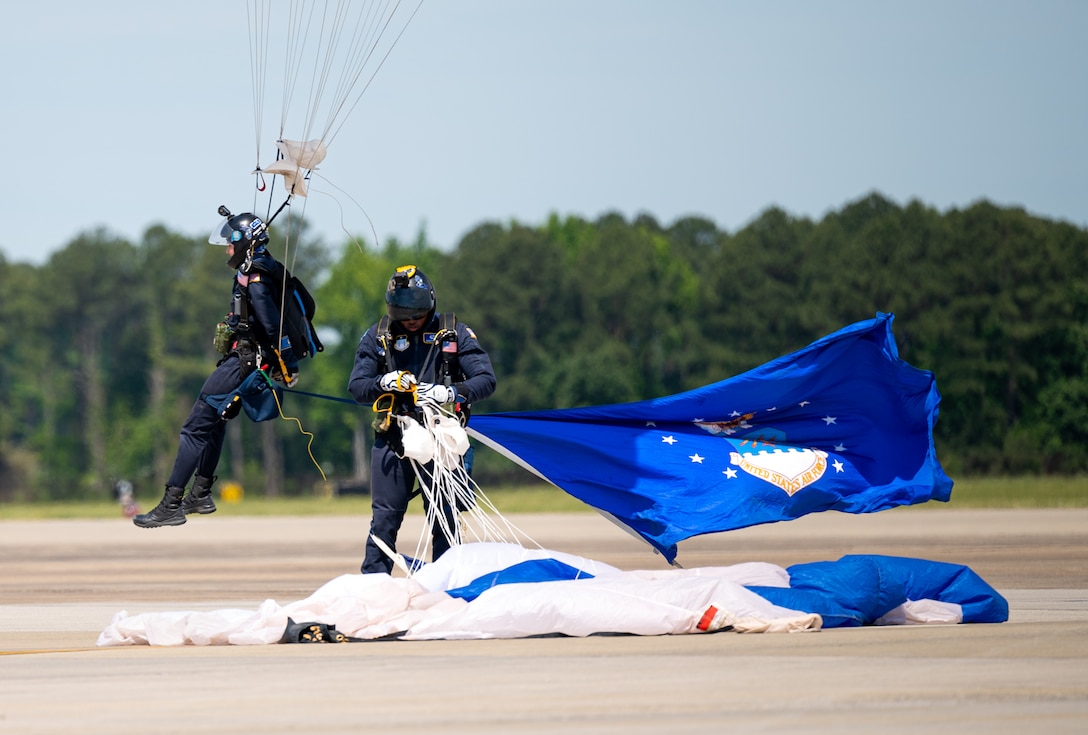 Parachute team members land on a flight land.