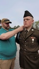 An Army Soldier receives blue infantry cord from his father.