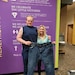 Pvt. Scott and fitness coach hold up old pair of jeans.