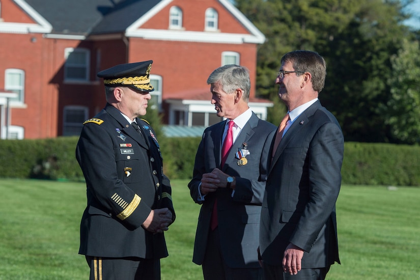 Three men stand together outdoors.