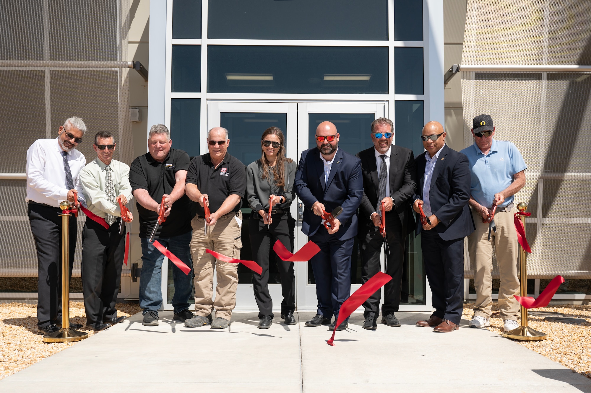 Stakeholders prepare to cut the ribbon at the Digital Test and Training Range Facility Ribbon-Cutting Ceremony at Edwards Air Force Base, California, May 8, 2023. The DTTR is specifically designed to meet the unique and complex needs of the Joint Simulation Environment. Equipped with cutting-edge technology, the facility enables Edwards' skilled test professionals to work more effectively and efficiently than ever. (U.S. Air Force Photo/Tech. Sgt. Robert Cloys)