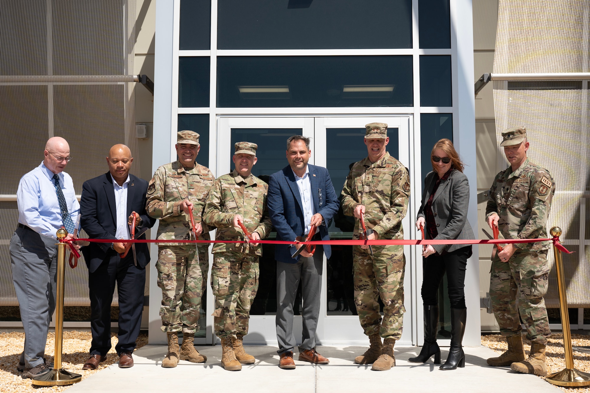 Stakeholders prepare to cut the ribbon at the Digital Test and Training Range Facility Ribbon-Cutting Ceremony at Edwards Air Force Base, California, May 8, 2023. The DTTR is specifically designed to meet the unique and complex needs of the Joint Simulation Environment. Equipped with cutting-edge technology, the facility enables Edwards' skilled test professionals to work more effectively and efficiently than ever. (U.S. Air Force Photo/Tech. Sgt. Robert Cloys)