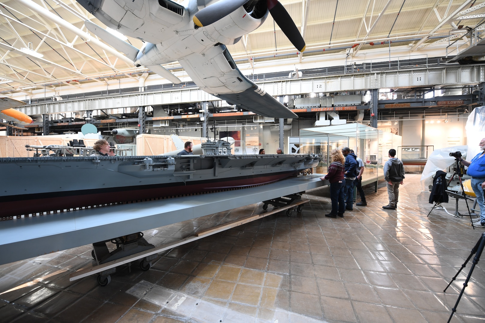 Carderock and National Museum of the U.S. Navy staff carefully maneuver the USS Forrestal model back into its case at its new home in the National Museum of the U.S. Navy at the Washington Navy Yard in Washington, D.C., on April 10. (U.S. Navy photo by Neubar Kamalian)