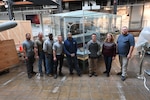 Naval Surface Warfare Center, Carderock Division’s model moving team poses in front of the USS Forrestal (CVA 59) model at its new home in the National Museum of the U.S. Navy at the Washington Navy Yard in Washington, D.C., on April 10. From left are: Marcus Gutierrez, Jimmy Schulze (Code 10212), Terry Goodwin, David Patton, Lewis D’Almeida, Brandon Patton, Jennifer Marland (Code 102B) and Brian Potter (Code 102B). (U.S. Navy photo by Neubar Kamalian)