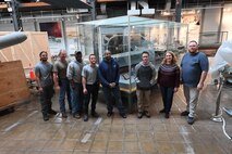 Naval Surface Warfare Center, Carderock Division’s model moving team poses in front of the USS Forrestal (CVA 59) model at its new home in the National Museum of the U.S. Navy at the Washington Navy Yard in Washington, D.C., on April 10. From left are: Marcus Gutierrez, Jimmy Schulze (Code 10212), Terry Goodwin, David Patton, Lewis D’Almeida, Brandon Patton, Jennifer Marland (Code 102B) and Brian Potter (Code 102B). (U.S. Navy photo by Neubar Kamalian)