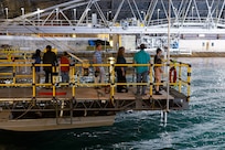 Naval Surface Warfare Center, Carderock Division employees and their children watch as waves are created in the Maneuvering and Seakeeping Basin in West Bethesda, Md., on April 27. (U.S. Navy photo by Kristin Behrle)