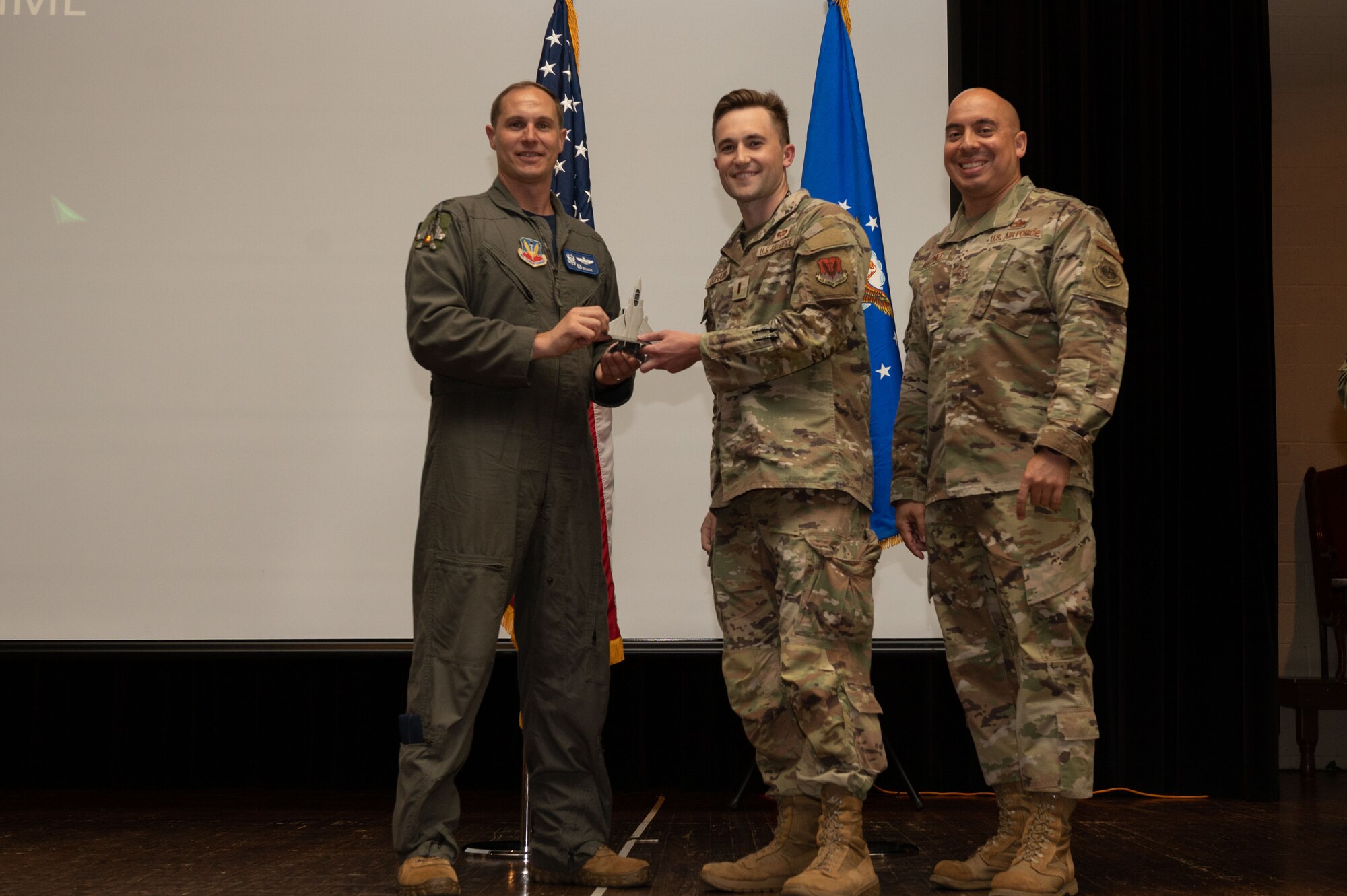 2nd Lt. Michael Duhaime, center, 4th Operations Support Squadron officer in charge of operations combat intelligence cell, receives the Junior Company Grade Officer of the Quarter award from Col. Lucas Teel, left, 4th Fighter Wing commander, and Chief Master Sgt. Peter Martinez, 4th FW command chief, during the 4th FW 1st Quarter Awards Ceremony at Seymour Johnson Air Force Base, North Carolina, May 5, 2023. Quarterly awards were awarded to Airmen and civilians in 12 different categories, to recognize the recipients exceptional work. (U.S. Air Force photo by Airman 1st Class Rebecca Sirimarco-Lang)