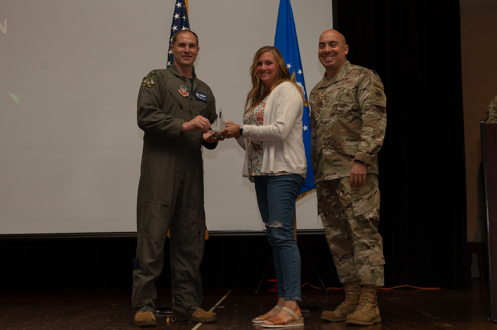 Catherine Pendleton, center, 4th Force Support Squadron management analyst, receives the Category II Civilian of the Quarter award from Col. Lucas Teel, left, 4th Fighter Wing commander, and Chief Master Sgt. Peter Martinez, 4th FW command chief, during the 4th FW 1st Quarter Awards Ceremony at Seymour Johnson Air Force Base, North Carolina, May 5, 2023. Quarterly awards were awarded to Airmen and civilians in 12 different categories, to recognize the recipients exceptional work. (U.S. Air Force photo by Airman 1st Class Rebecca Sirimarco-Lang)
