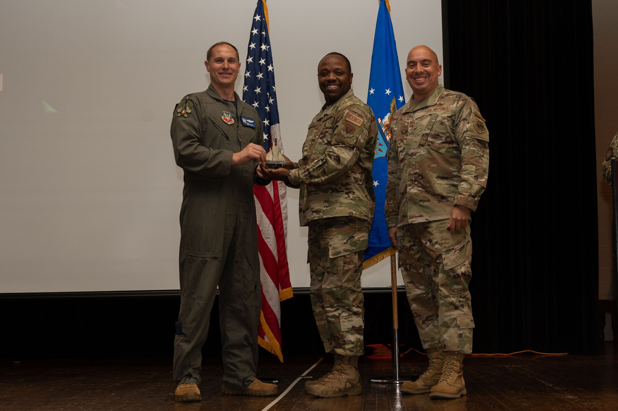 Chief Master Sgt. Jasper Martin, center, 4th Maintenance Group maintenance operations senior enlisted leader, accepts the Category III Civilian of the Quarter award from Col. Lucas Teel, left, 4th Fighter Wing commander, and Chief Master Sgt. Peter Martinez, 4th FW command chief, on behalf of his wife, Kenya Martin, 4th Contracting Squadron contracting specialist, during the 4th FW 1st Quarter Awards Ceremony at Seymour Johnson Air Force Base, North Carolina, May 5, 2023. Quarterly awards were awarded to Airmen and civilians in 12 different categories, to recognize the recipients exceptional work. (U.S. Air Force photo by Airman 1st Class Rebecca Sirimarco-Lang)