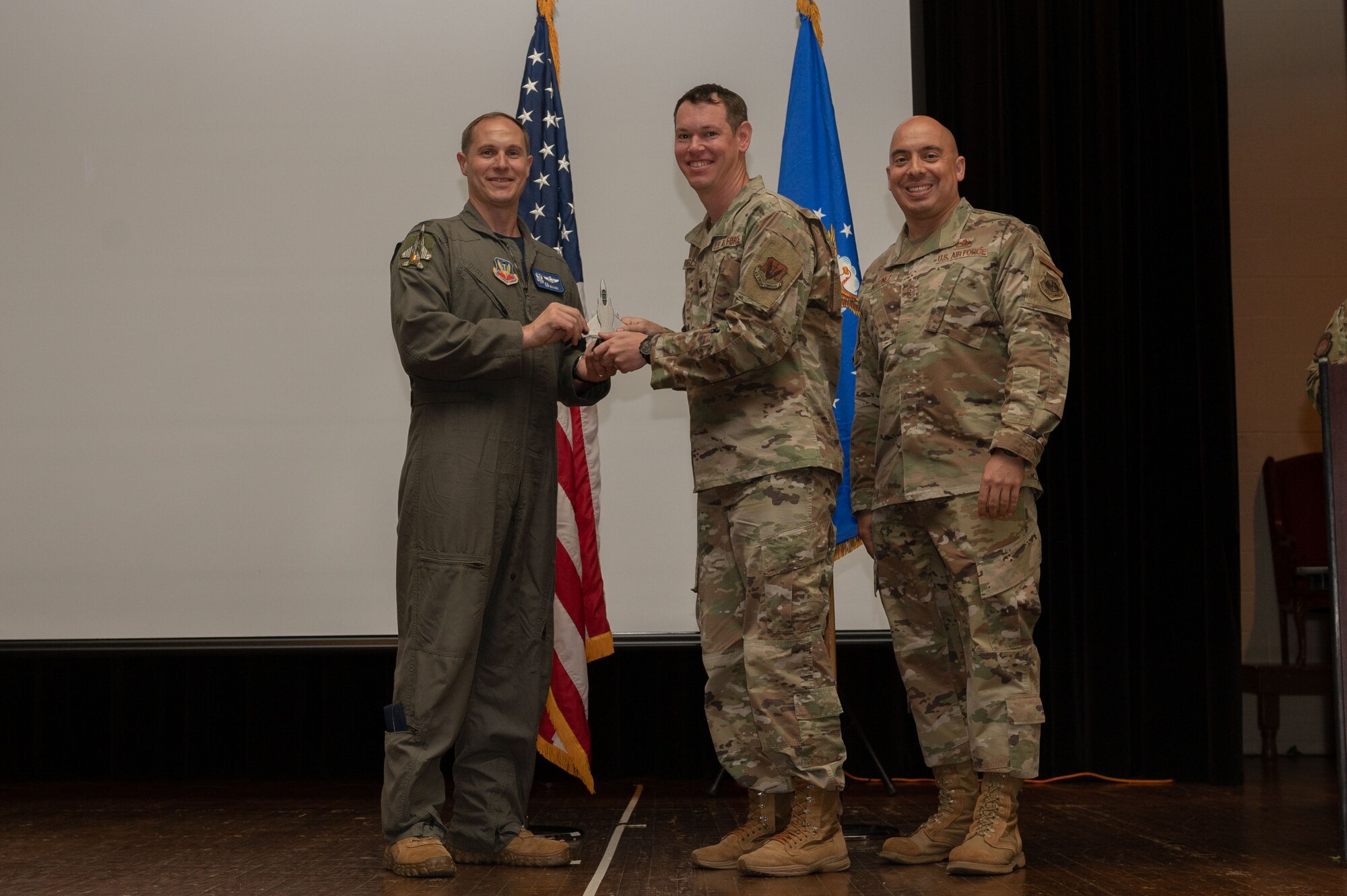 Lt Col. Timothy Kirchner, center, 4th Force Support Squadron commander, receives the Honor Guardsman of the Quarter award from Col. Lucas Teel, left, 4th Fighter Wing commander, and Chief Master Sgt. Peter Martinez, 4th FW command chief, on behalf of Airman 1st Class Denzell Foyles, 4th Equipment Maintenance Squadron nondestructive inspection apprentice, during the 4th FW 1st Quarter Awards Ceremony at Seymour Johnson Air Force Base, North Carolina, May 5, 2023. Quarterly awards were awarded to Airmen and civilians in 12 different categories, to recognize the recipients exceptional work. (U.S. Air Force photo by Airman 1st Class Rebecca Sirimarco-Lang)