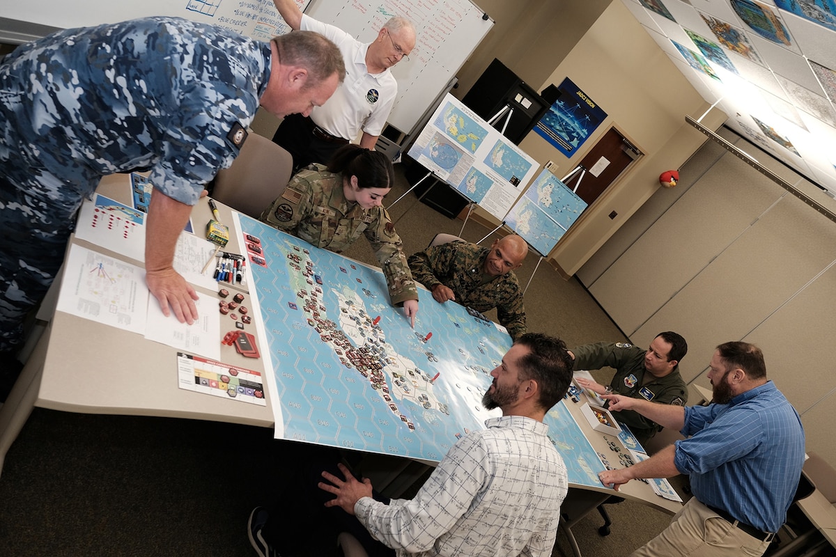 Uniformed US and Royal Australian Air Force members along with civilians test new Kingfish gameboard for Air Operations Center Initial Qualification Training Course