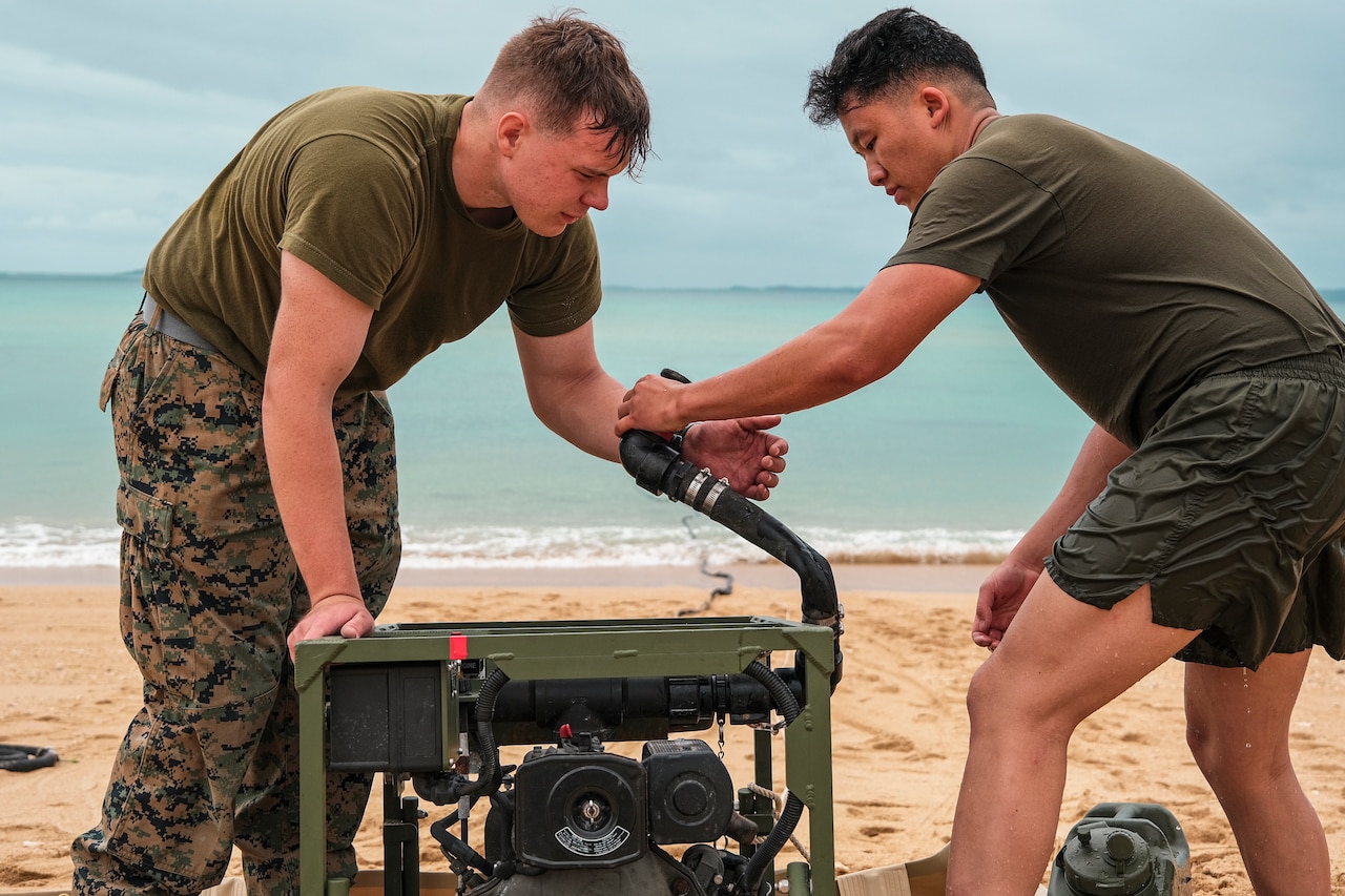 Two Marines set up a water purification system.