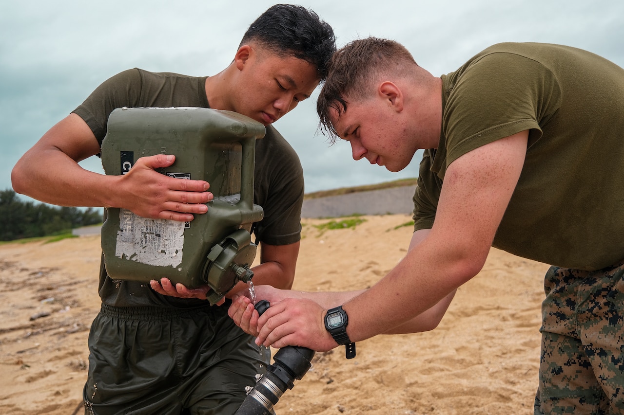 Two Marines set up a water purification system.