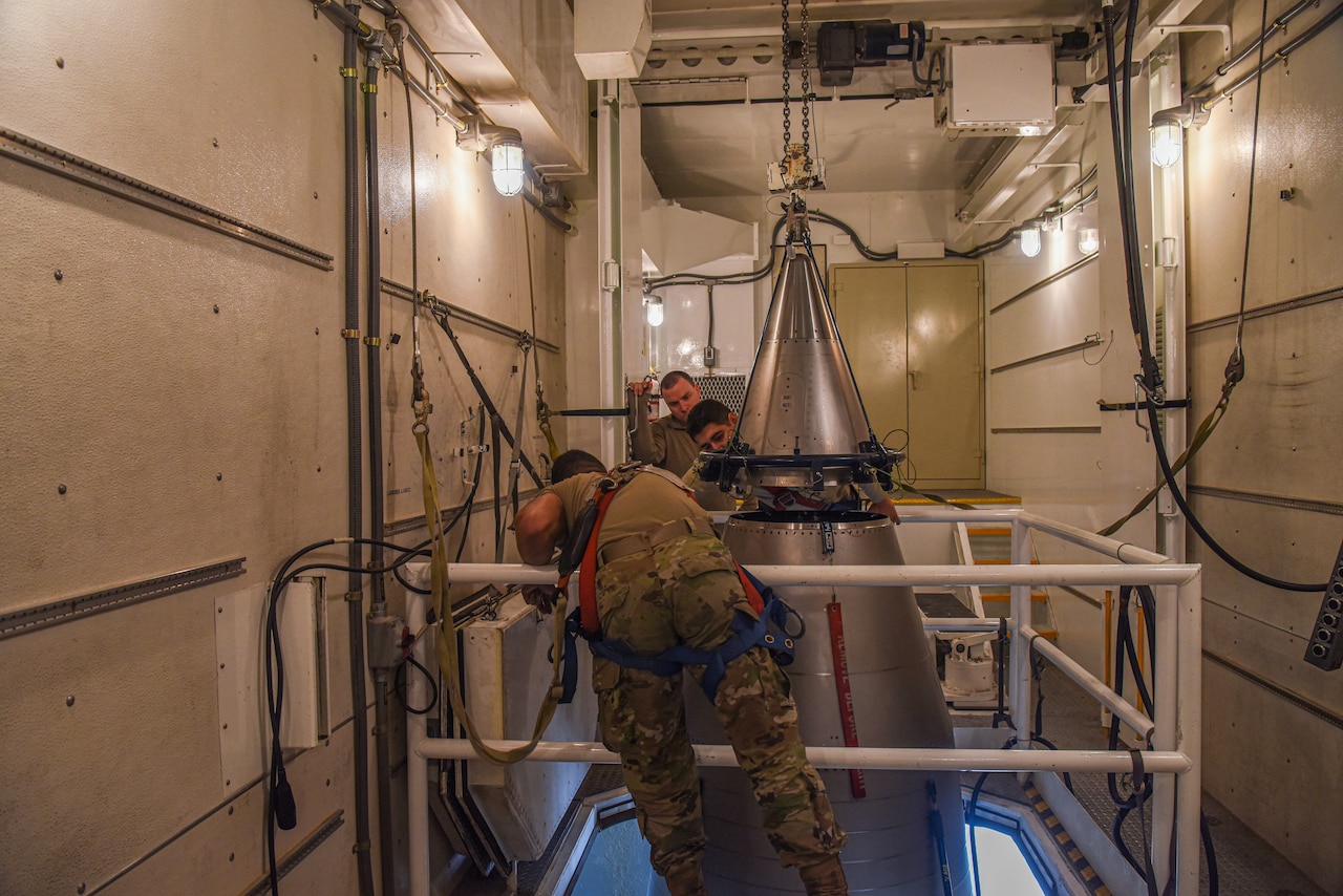 Airmen work on a missile.