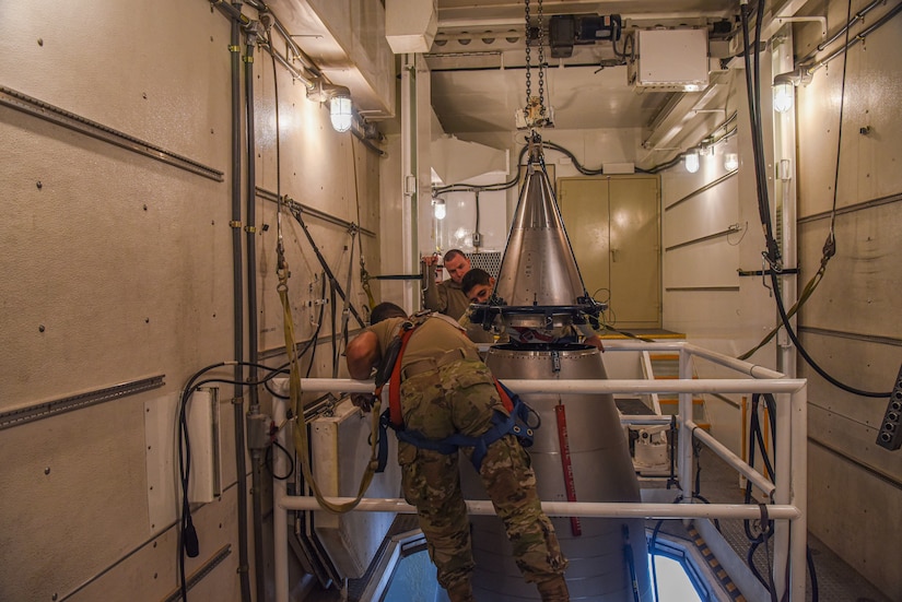 Airmen work on a missile.