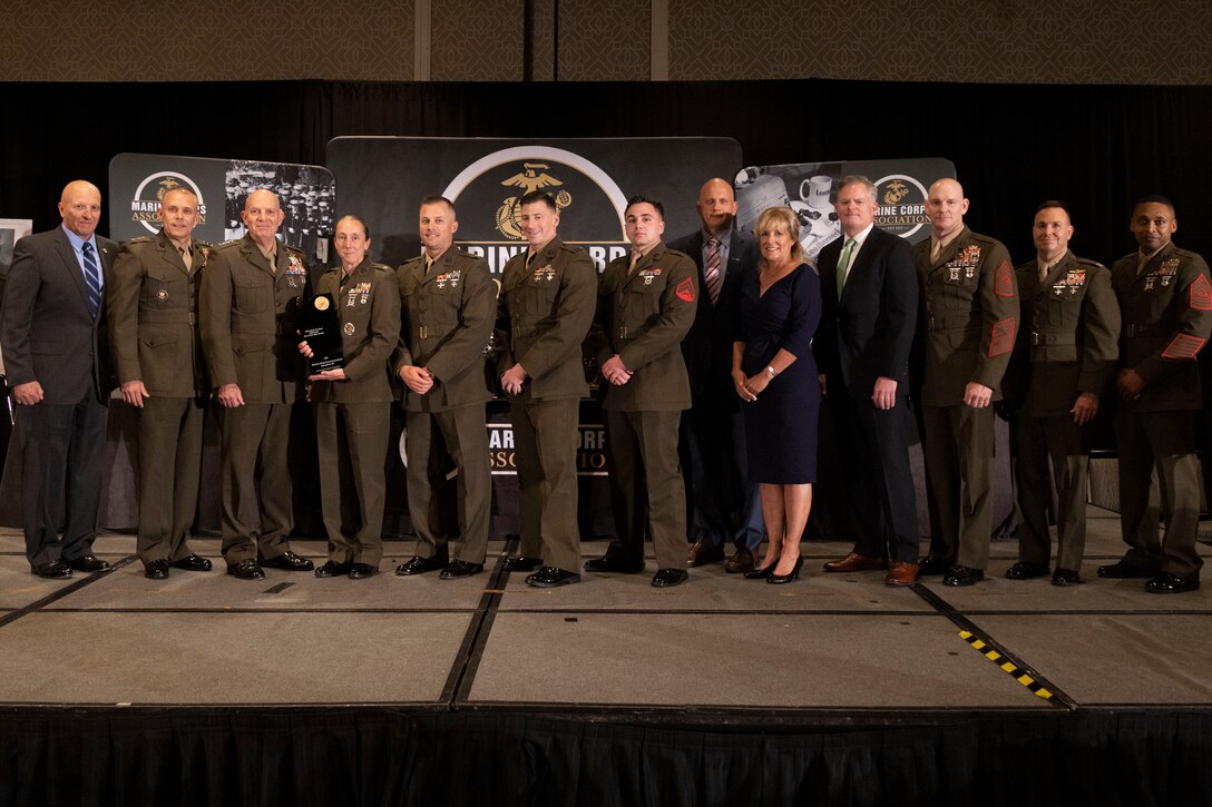 U.S. Marines with Marine Wing Communications Squadron 38 pose for a photo with senior leadership at the annual Marine Corps Association information awards dinner in Arlington, Virginia, April 20, 2023. MWCS-38 received the Lt. Col. Kevin M. Shea Memorial Unit of the Year Award for significant contributions to the Marine Corps information occupational fields. MWCS-38 belongs to 3rd Marine Aircraft Wing, I Marine Expeditionary Force. (U.S. Marine Corps photo by Sgt. Rachaelanne Woodward)