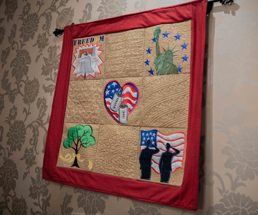 A red-framed quilt highlights symbols of American patriotism.