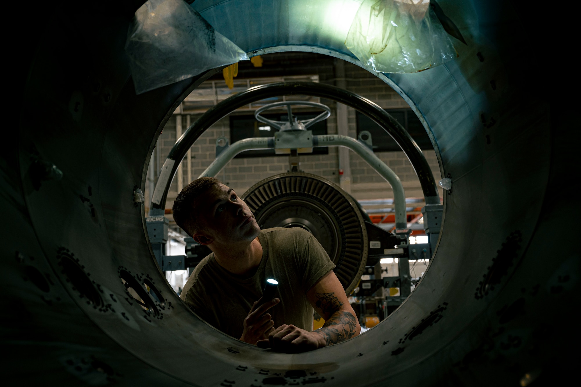 U.S. Air Force Airman 1st Class Anthony Young, 49th Component Maintenance Squadron aerospace propulsion journeyman, inspects the interior of a Pratt and Whitney F100 engine at Holloman Air Force Base, New Mexico, May 3, 2023. The 49th CMS aerospace propulsion shop is responsible for the maintenance of all F-16 Viper engines on base, ensuring they are at maximum efficiency for Holloman’s pilots. (U.S. Air Force photo by Airman 1st Class Isaiah Pedrazzini)