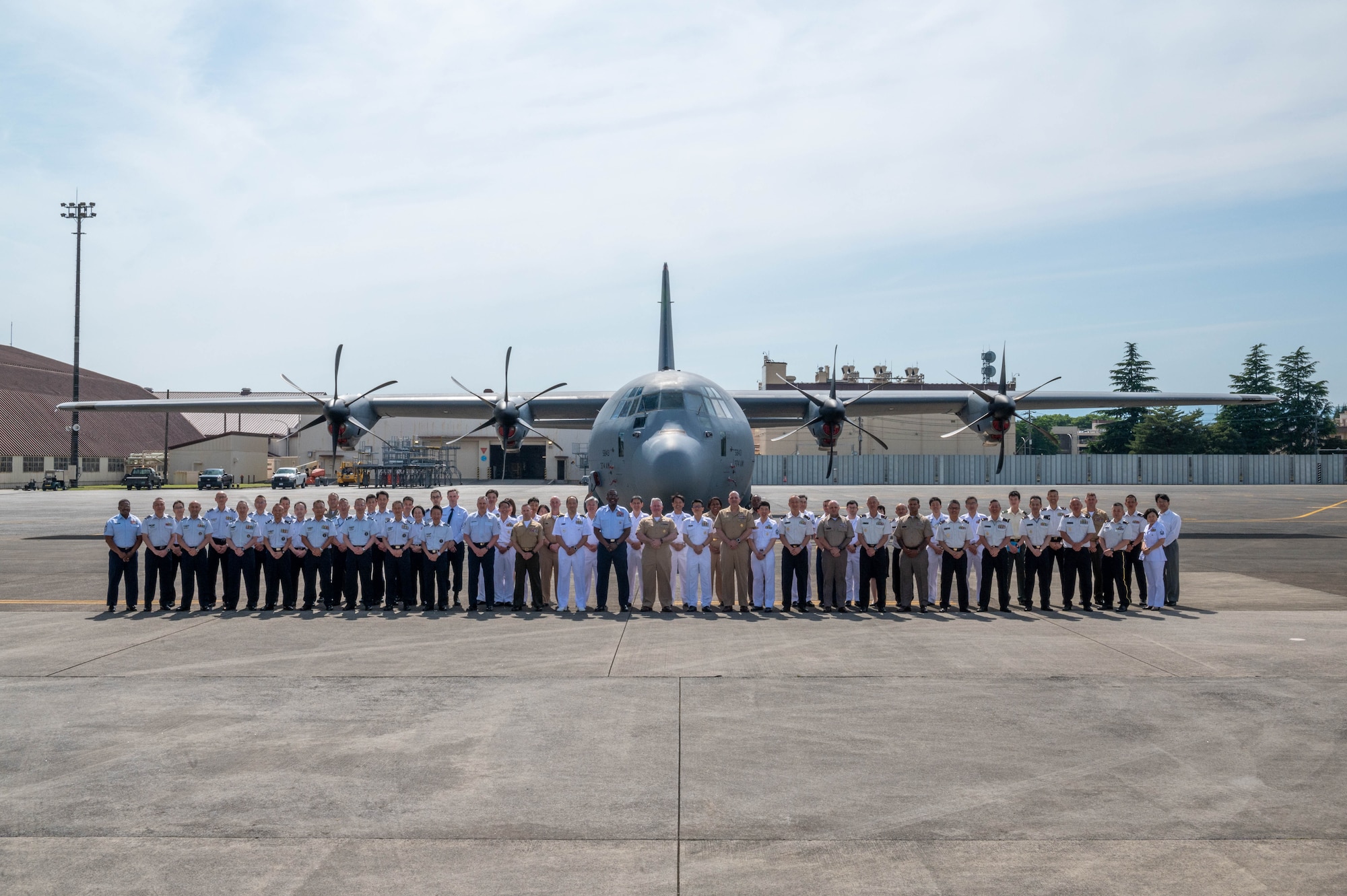 American and Japanese military members pose for a group photo in front of a C-130J Super Hercules at Yokota Air Base, Japan.
