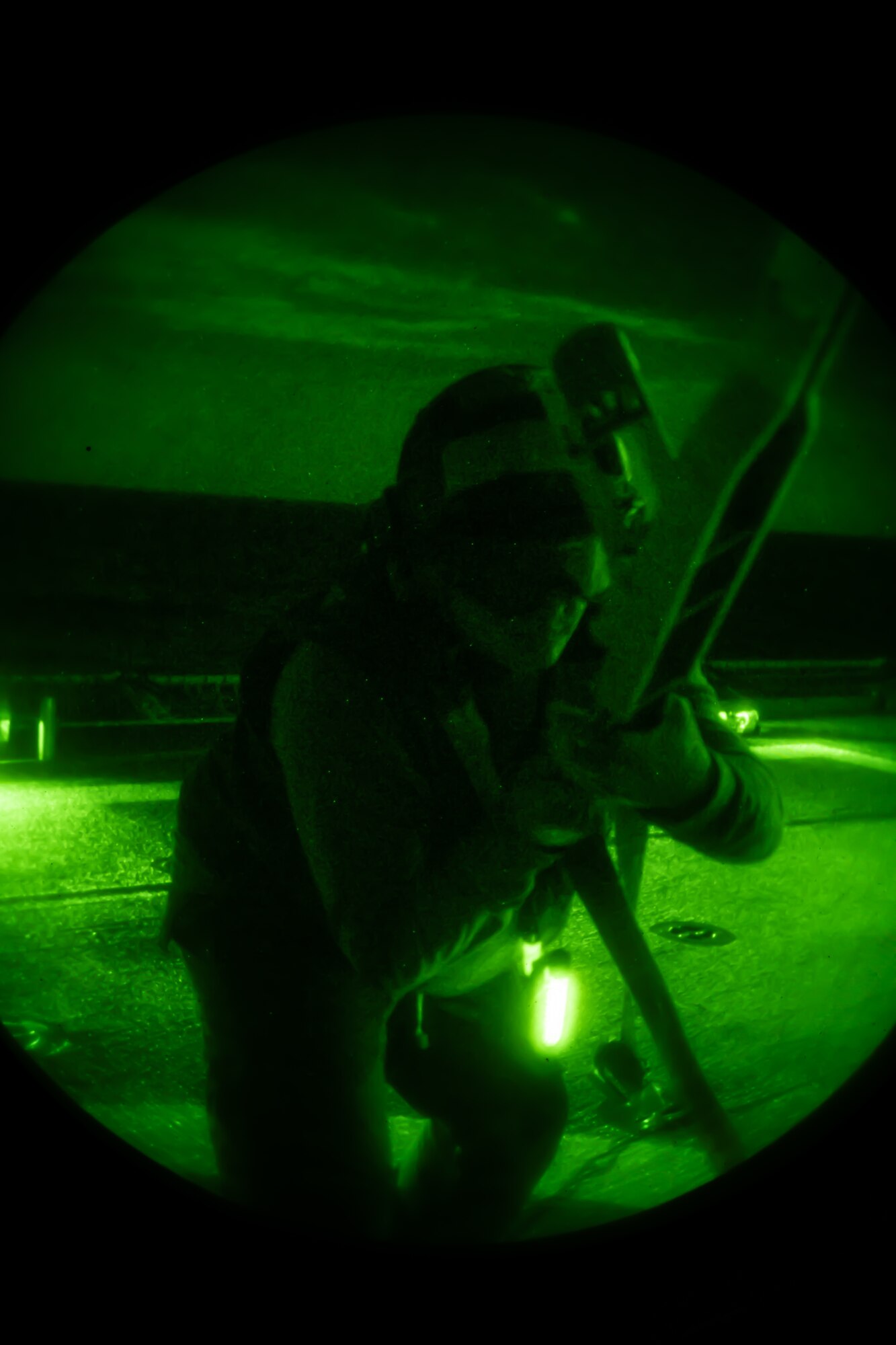 A U.S. Coast Guardsman secures an aircraft to the deck during nighttime training with the 33rd Rescue Squadron off the coast of Okinawa, Japan, May 5, 2023. The training allows naval and flying units to coordinate and conduct operations with limited visibility. (U.S. Air Force photo by Senior Airman Cedrique Oldaker)