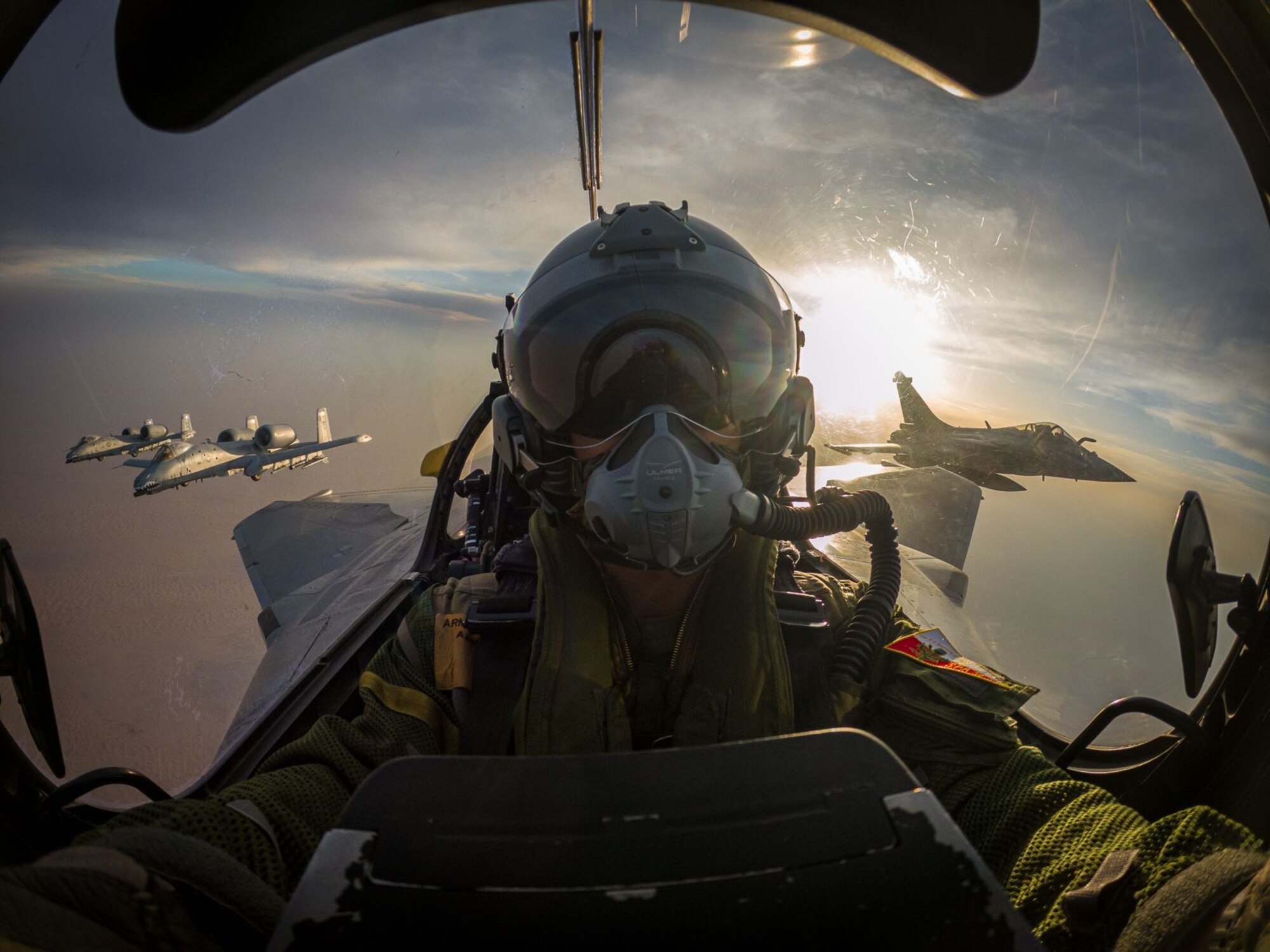 A pilot flies in formation with three other jets.