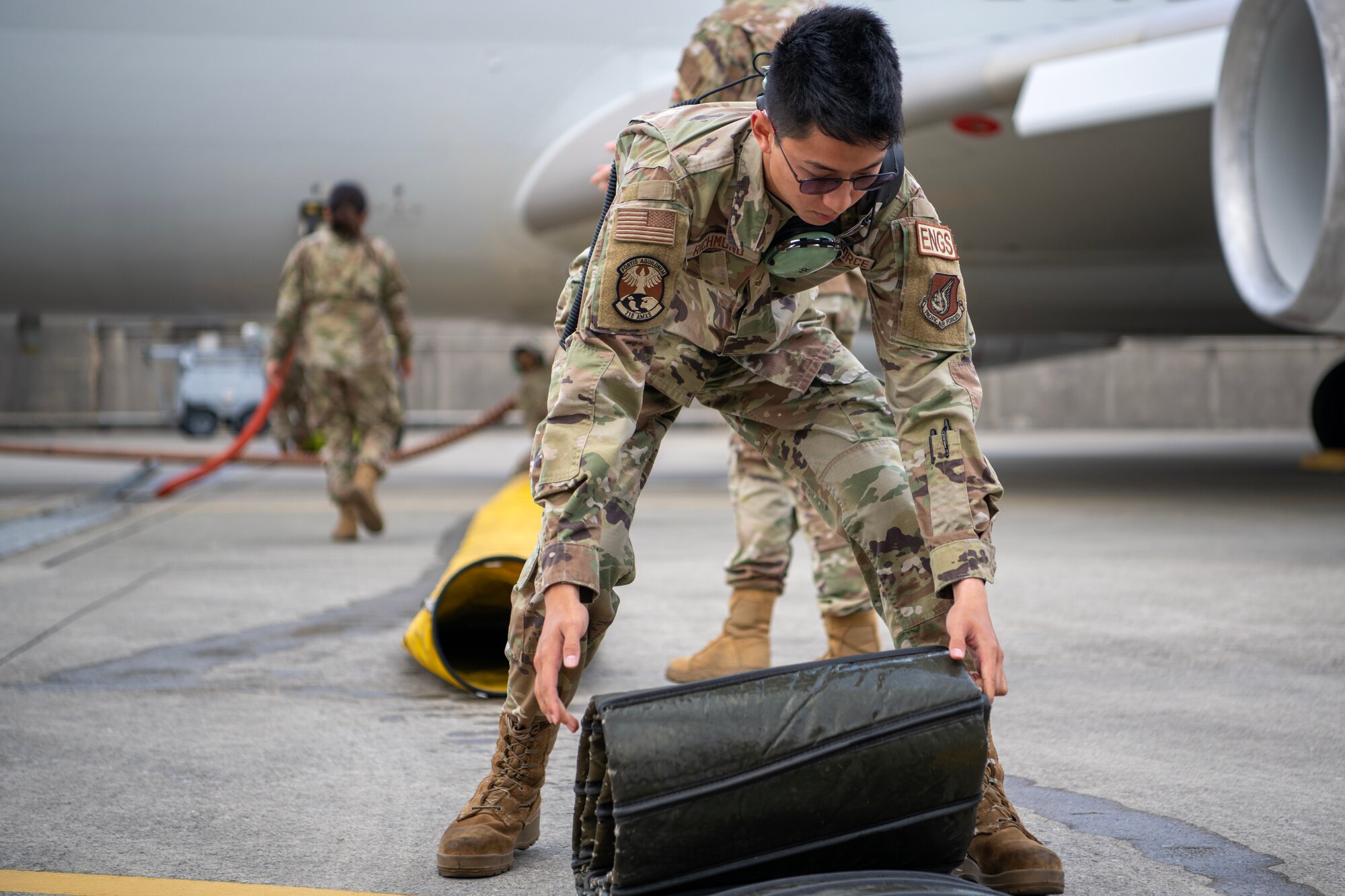 Airman rolls detached tubing from an AWACS