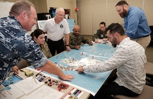 Uniformed US and Royal Australian Air Force members along with civilians test new Kingfish gameboard for Air Operations Center Initial Qualification Training Course