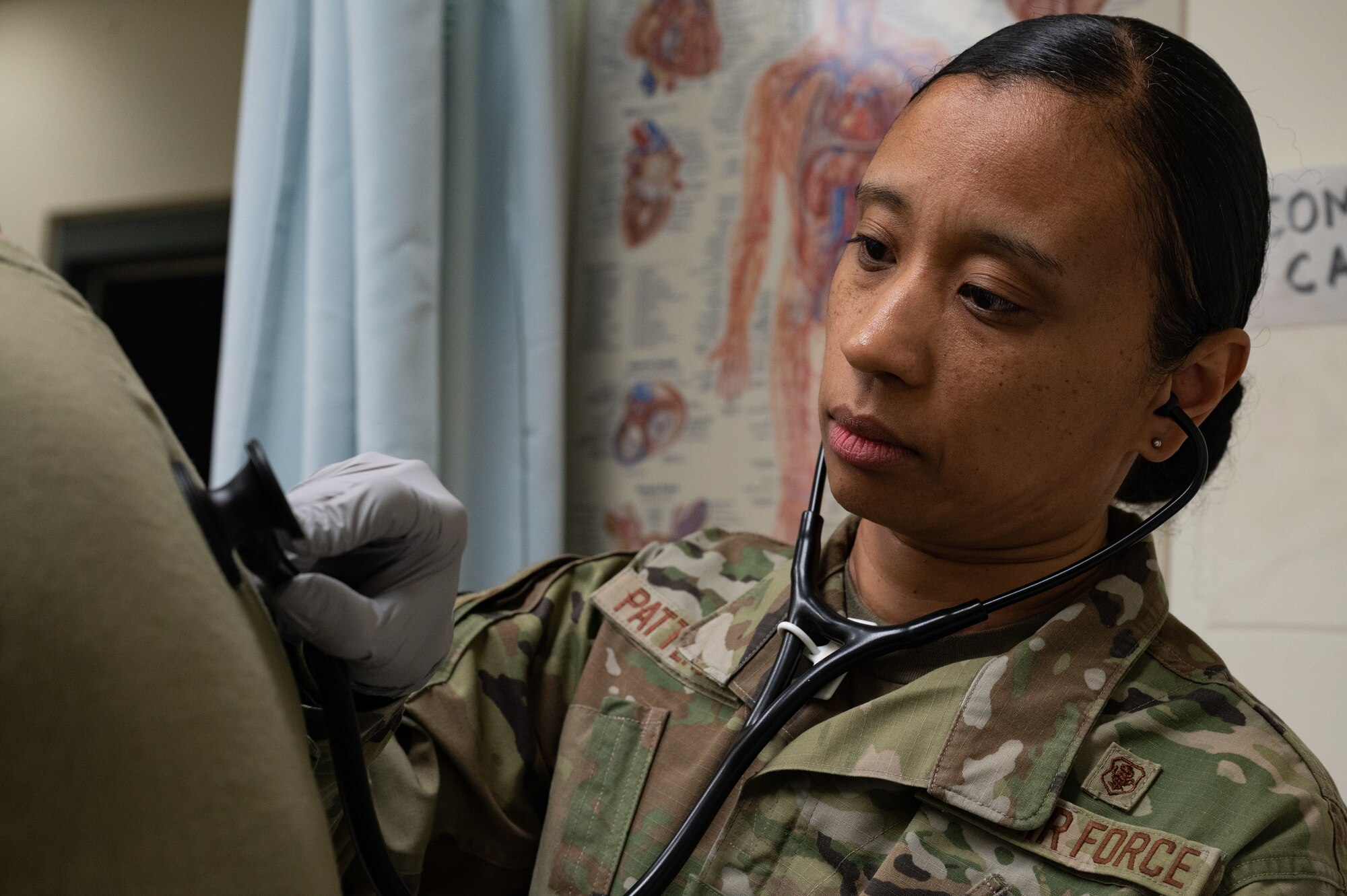 A nurse uses a stethoscope on a patient