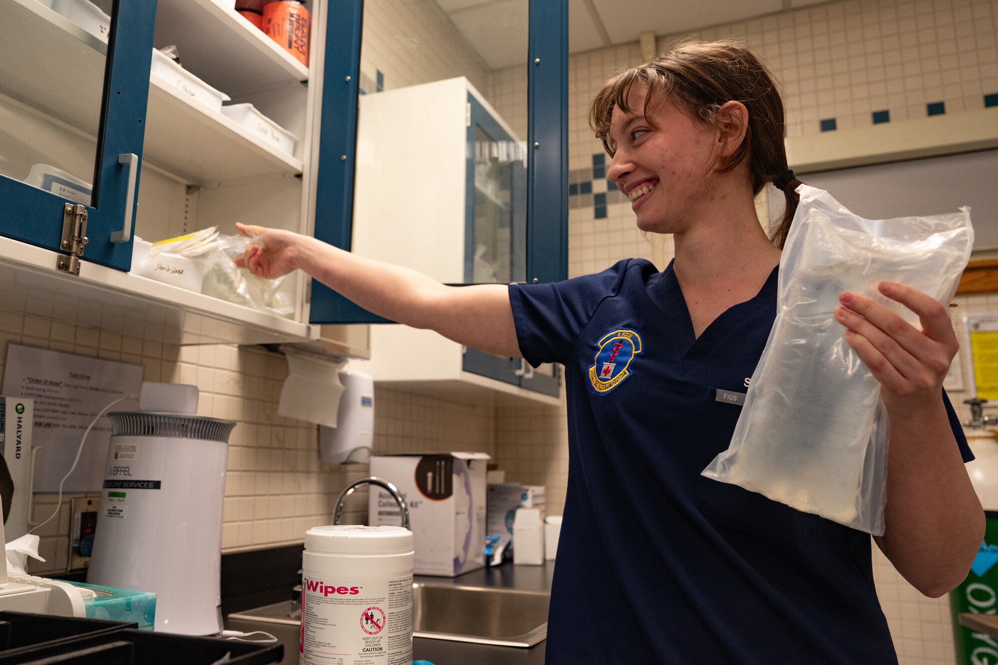 A woman organizes fluids in a storage room