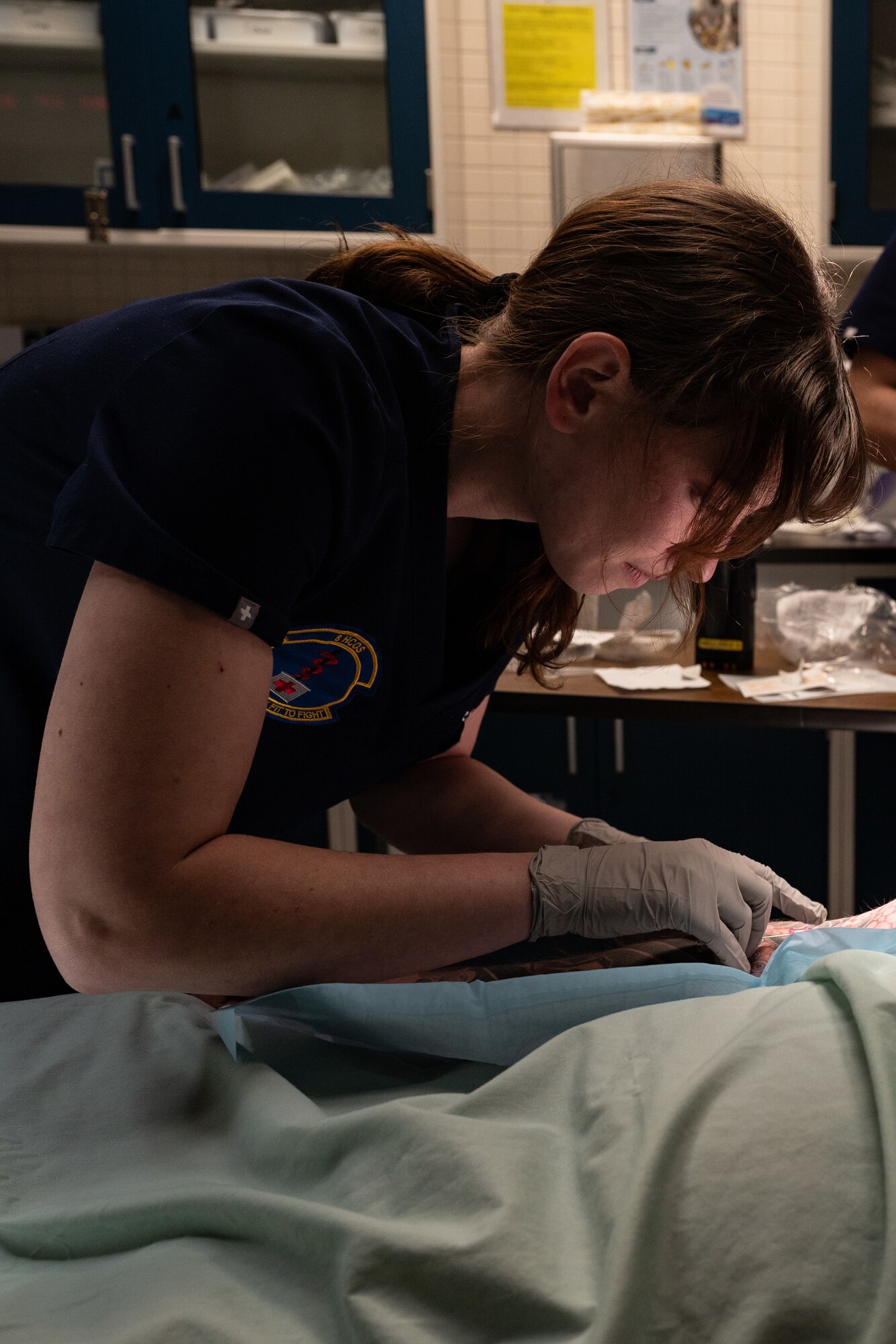 A woman tends to an IV tube on a patient