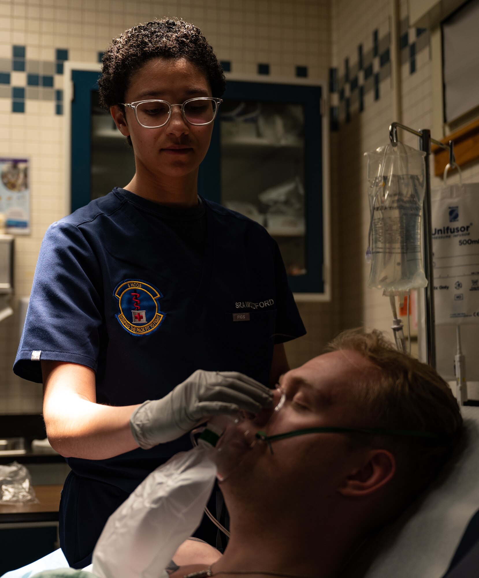 woman holds an oxygen mask to a patient