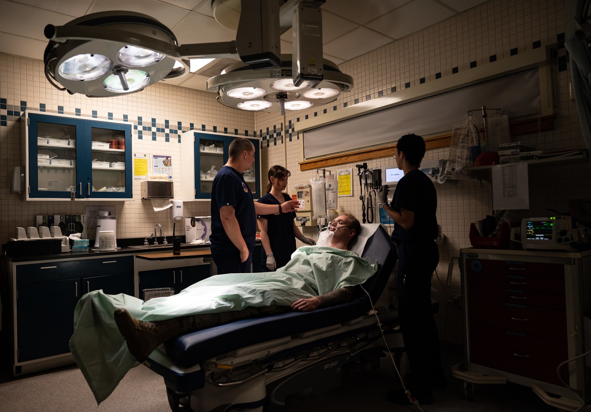 people gather around a patient bed