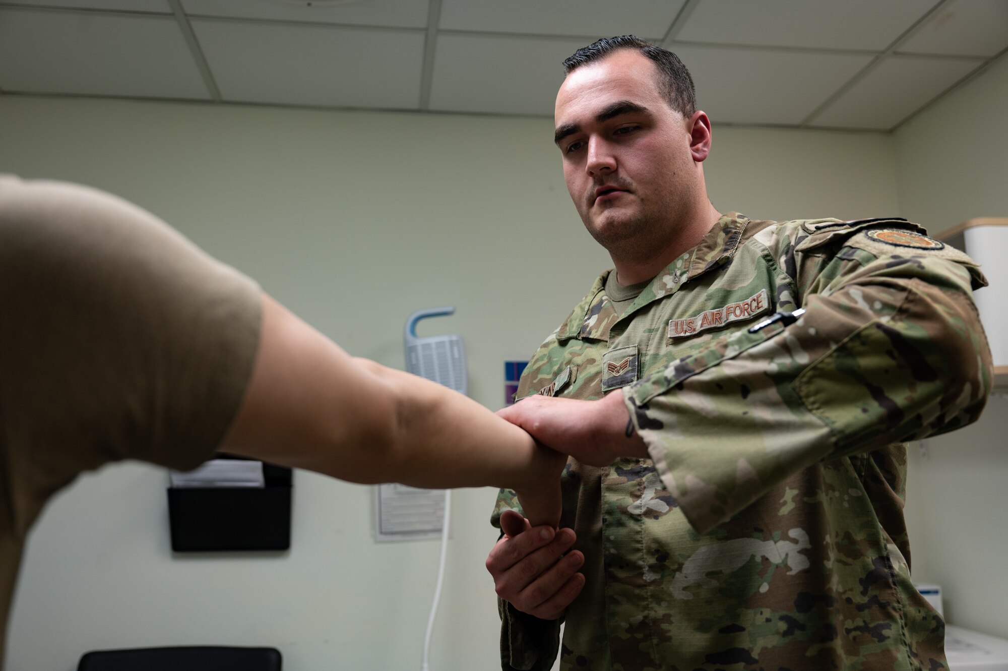 man checks a patient's arm