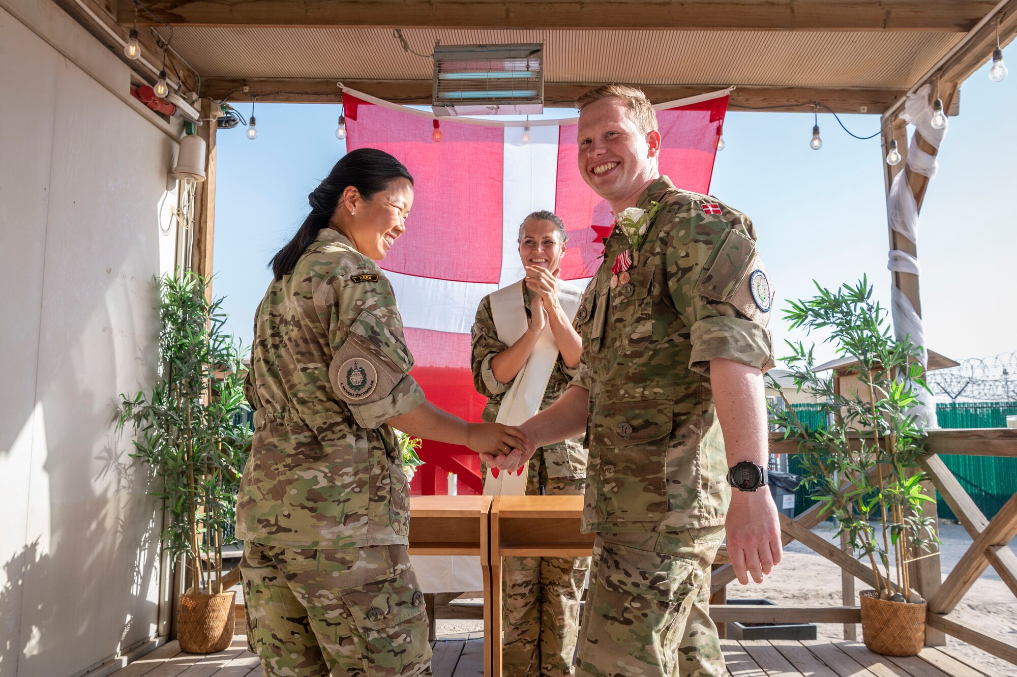 Sergeant 1st Class Signe Li Jakobsen, left, and Sergeant 1st Class Mads Petersen, right, Danish National Support Element quartermasters, get married at Ali Al Salem Air Base, Kuwait, May 3, 2023.