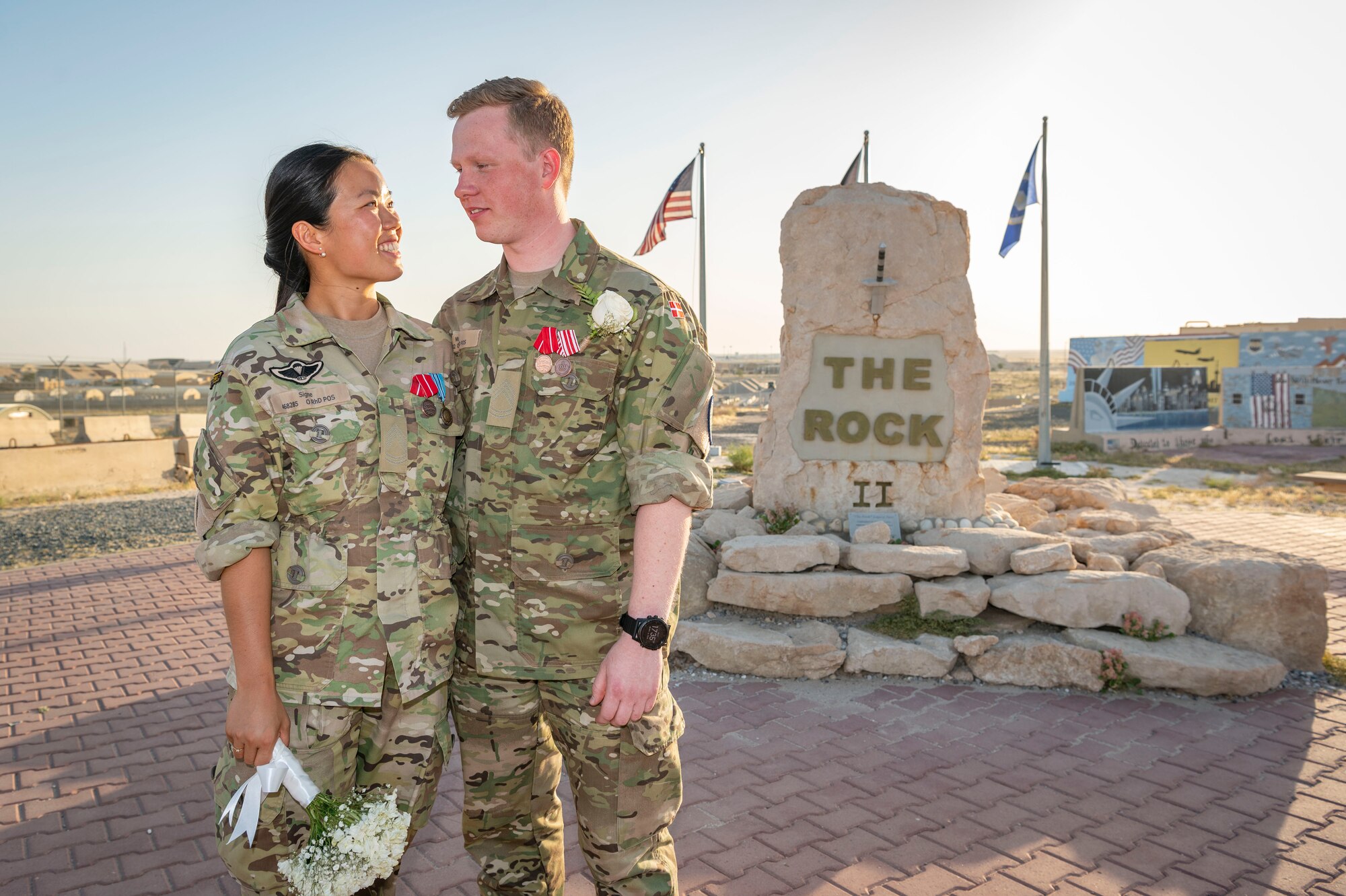 Sergeant 1st Class Signe Li Jakobsen, left, and Sergeant 1st Class Mads Petersen, right, Danish National Support Element quartermasters, pose for a photo after their wedding at Ali Al Salem Air Base, Kuwait, May 3, 2023.