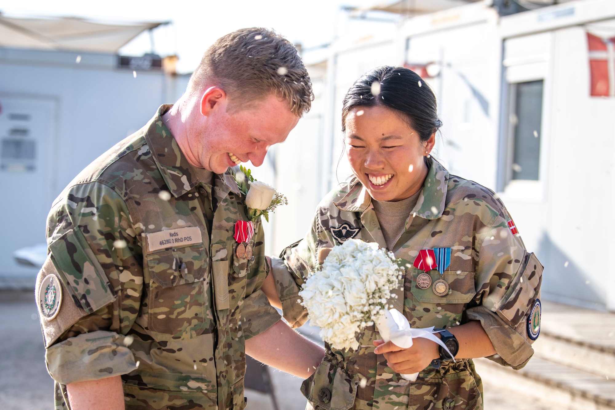 Sergeant 1st Class Mads Petersen, left, and Sergeant 1st Class Signe Li Jakobsen, right, Danish National Support Element quartermasters, are celebrated during their wedding at Ali Al Salem Air Base, Kuwait, May 3, 2023.
