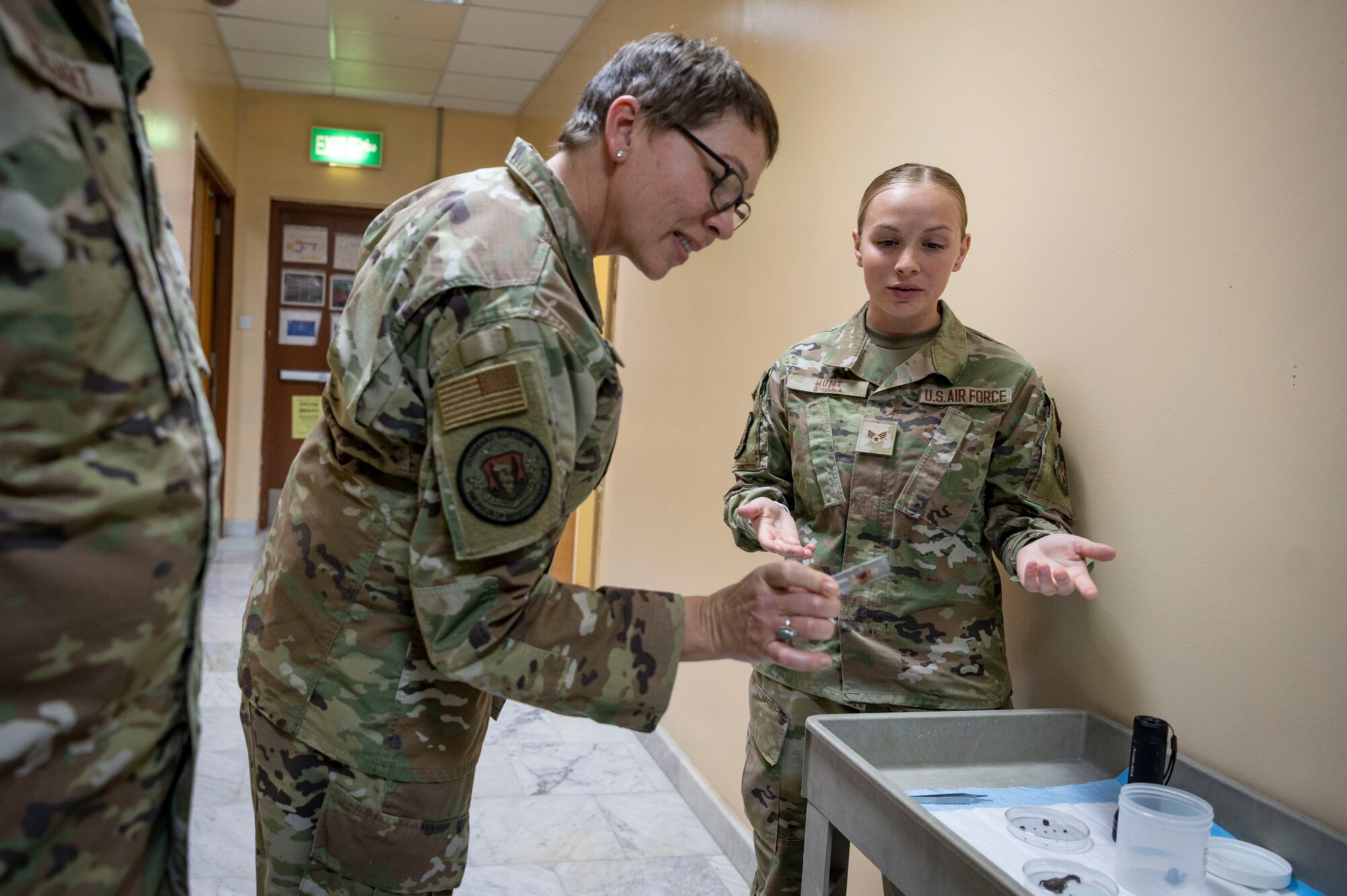 U.S. Air Force Senior Airman Emily Hunt, a 386th Expeditionary Medical Squadron public health specialist, explains the different species of scorpions found in the area to Chief Master Sgt. Kimberly Green, Air Combat Command Office of the Surgeon General chief, medical enlisted force, during a tour at Ali Al Salem Air Base, Kuwait, May 8, 2023.