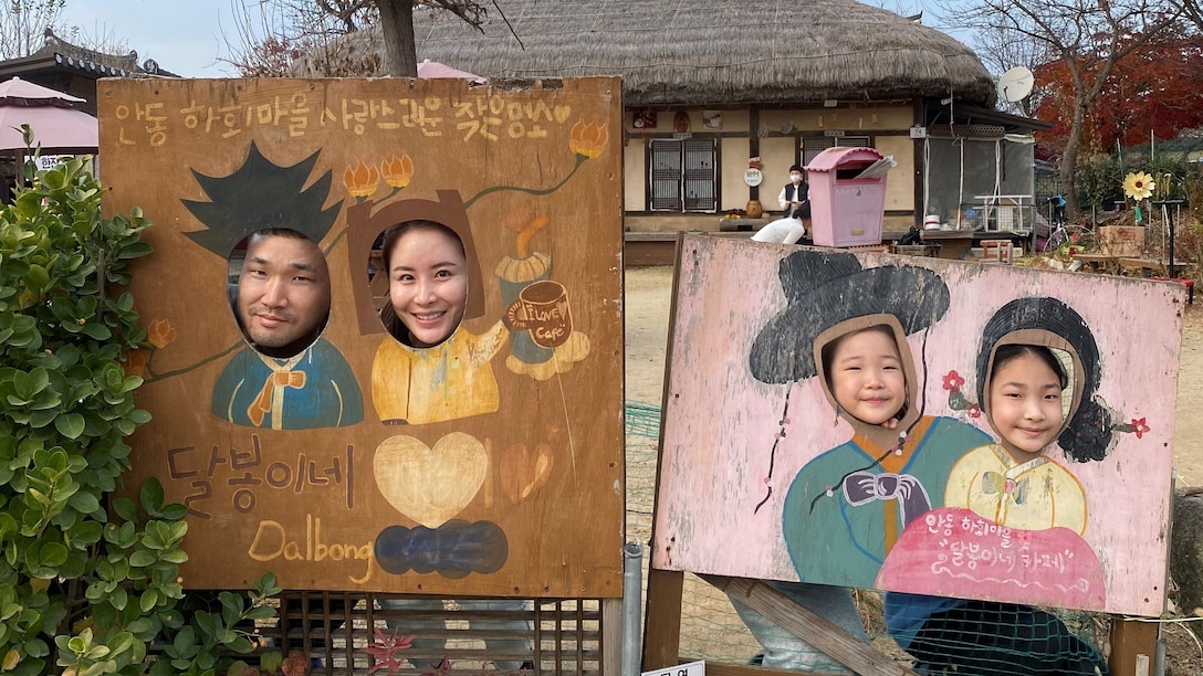 a family of four stand behind a large Korean sculpture