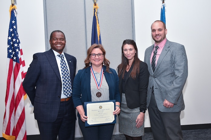 Naval Surface Warfare Center, Philadelphia Division (NSWCPD) Chemical Engineer Jay Smith receives a Bronze Medal during the annual Philadelphia FEB Excellence in Government Awards Ceremony on May 4, 2023. Smith was honored for her contributions to developing the critical submarine life-support system, the Advanced Carbon Dioxide Removal Unit (ACRU), on the Columbia class submarine. Pictured with Smith are NSWCPD Technical Director Nigel C. Thijs, Machinery Research, Logistics, and Ship Integrity Department Head Allison Hollish and Energy Conversion R&D Branch Head Jake Kephart. (Courtesy Photo by Celynda Cortez)