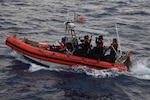 A USCGC Thetis (WMEC 910) boarding team departs via small boat with CG-P6 dewatering pumps and jugs of drinking water to provide rescue assistance to a Haitian sailing vessel taking on water off the coast of Ile de la Tortue, Haiti, March 14, 2023. While patrolling off the coast of Haiti, Thetis watch standers spotted sailors aboard a Haitian sailboat waving their arms indicating distress. (U.S. Coast Guard photo by Petty Officer 3rd Class Elijah De La Torre)